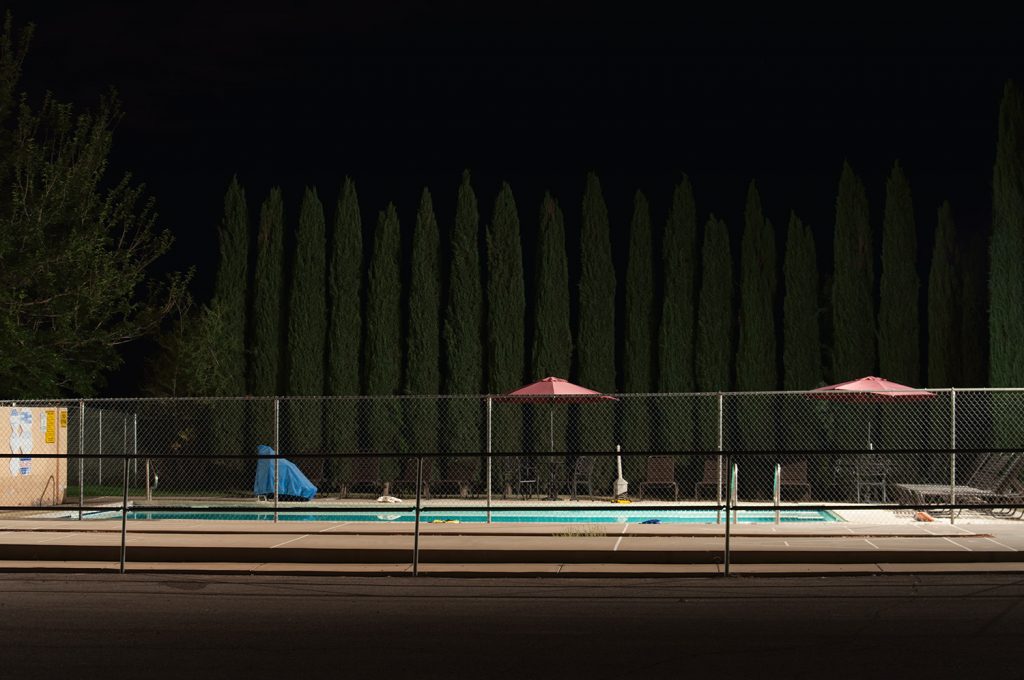 A Pool at night with trees in the background